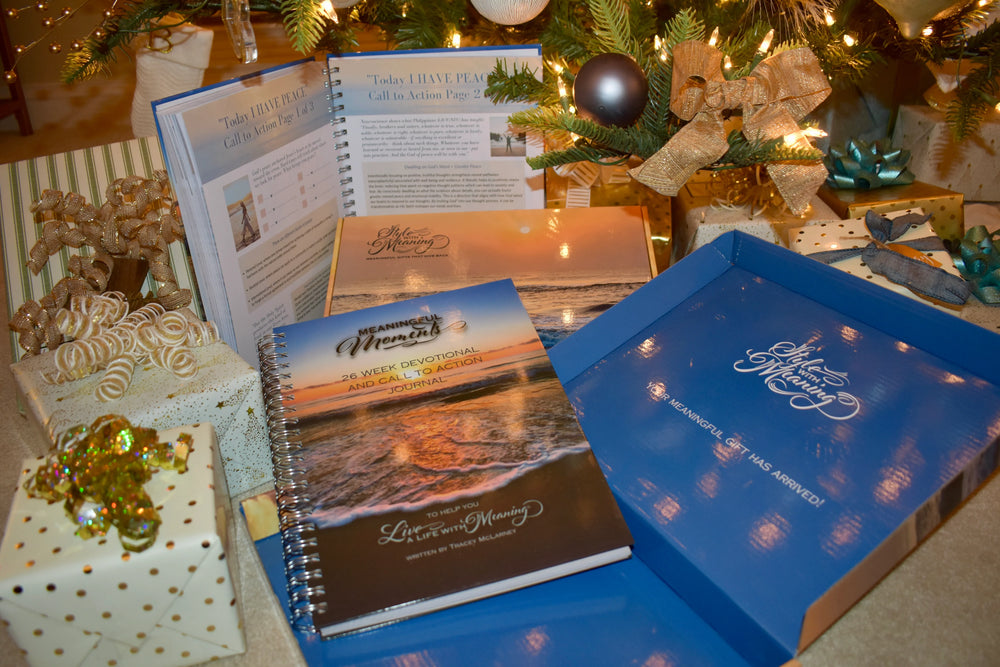 Devotional Books with gift boxes under a Christmas tree in the background